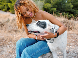 Woman hugging her dog outside.