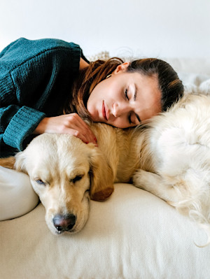 Woman hugging her Labrador dog at home.