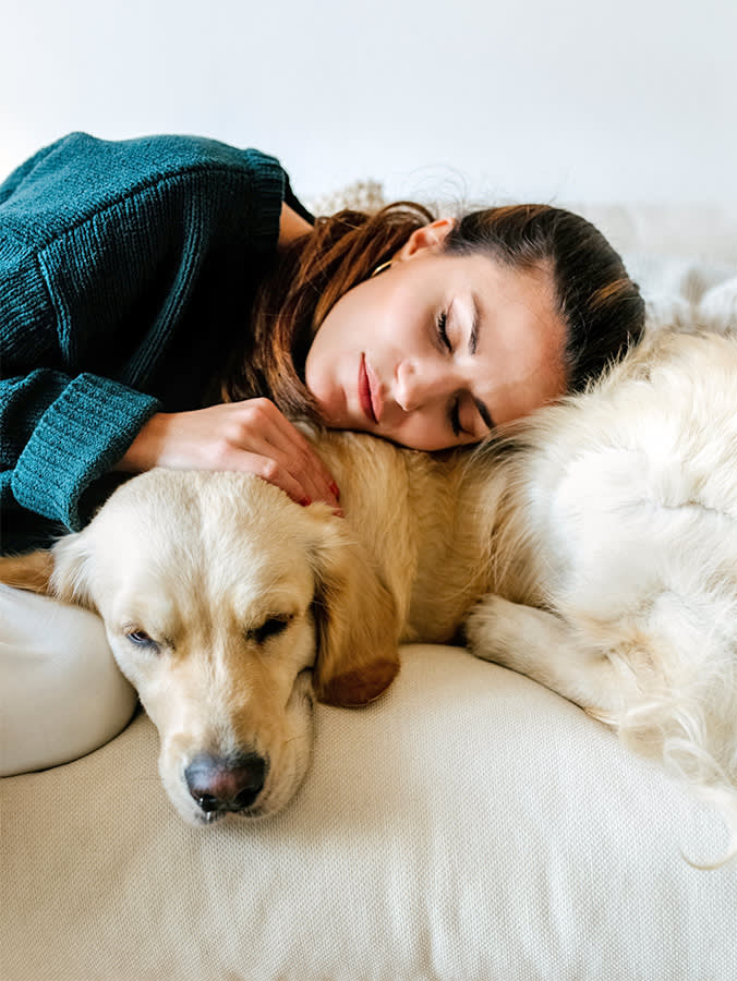 Woman hugging her Labrador dog at home.