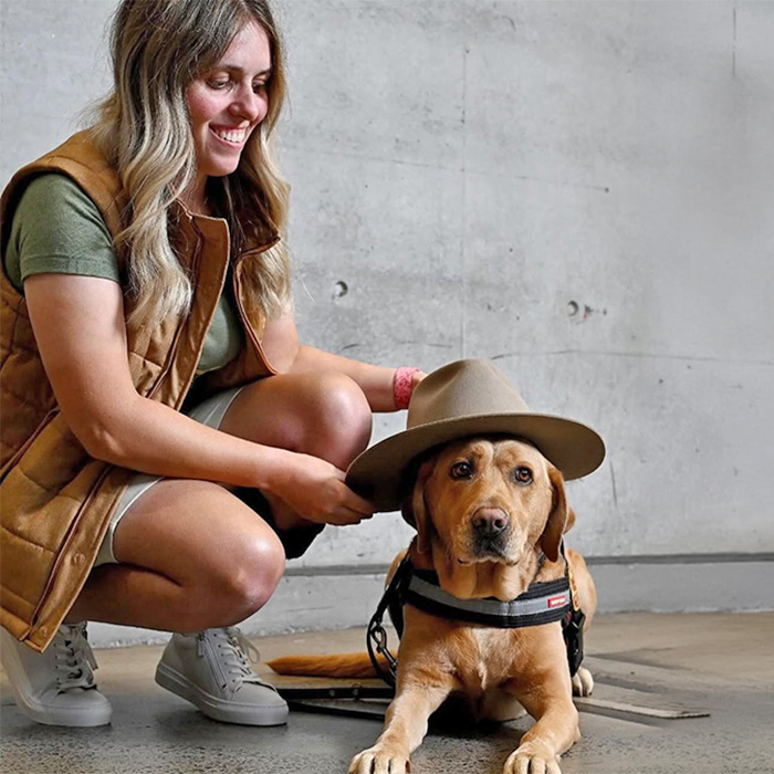 Amanda Reid puts a hat on her service dog, Odell