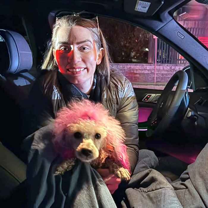 Molly, a pink Poodle, with her former guardian 