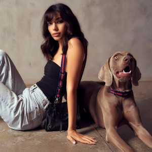 Woman wearing Saint Rue bag sitting next to dog wearing matching Saint Rue collar