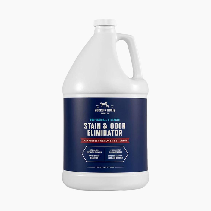 stain and odor eliminator in white bottle with navy blue logo