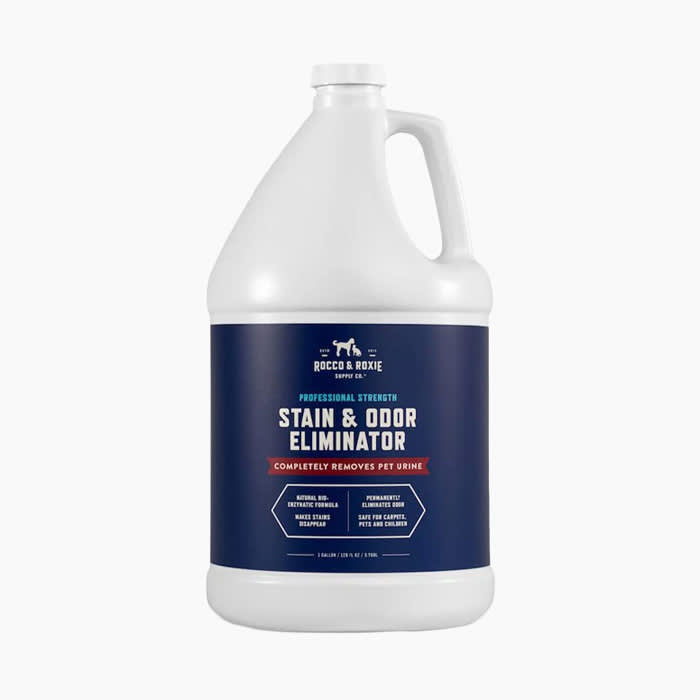 stain and odor eliminator in white bottle with navy blue logo