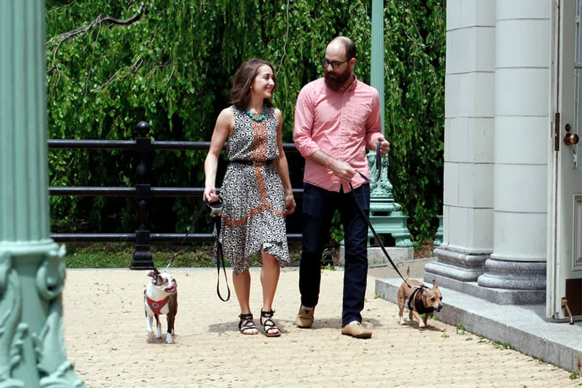 two foster volunteers walk dogs