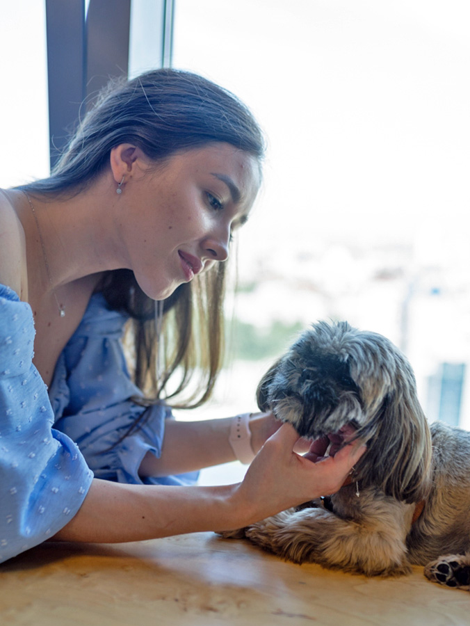 Woman looking closely at her dog&#x27;s face.