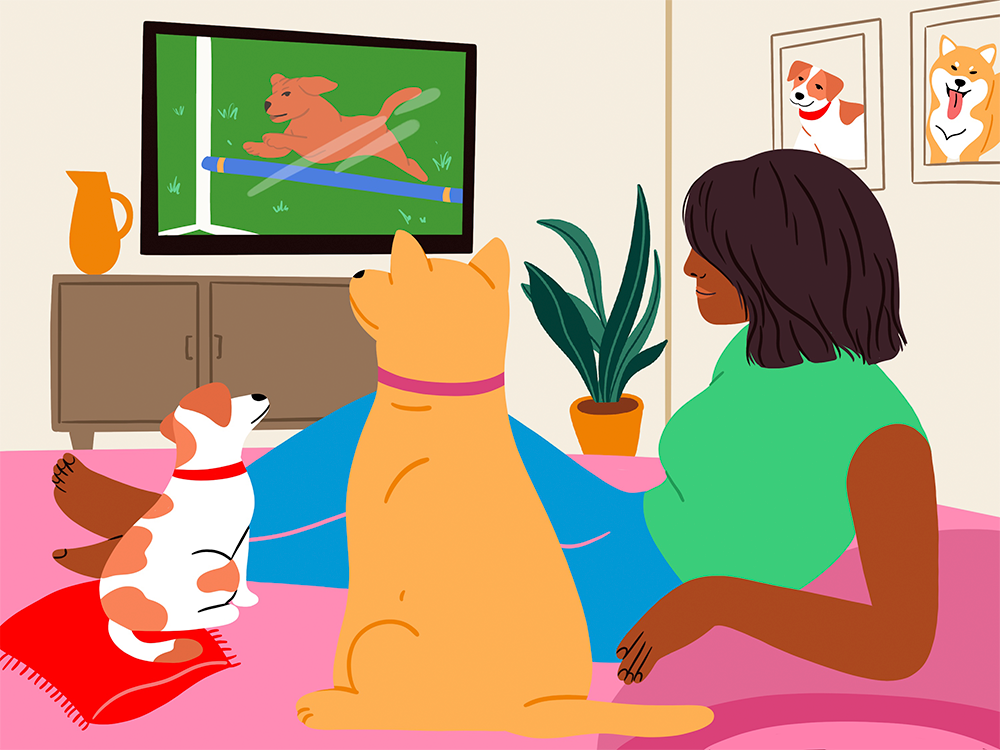 woman watching TV with her dogs