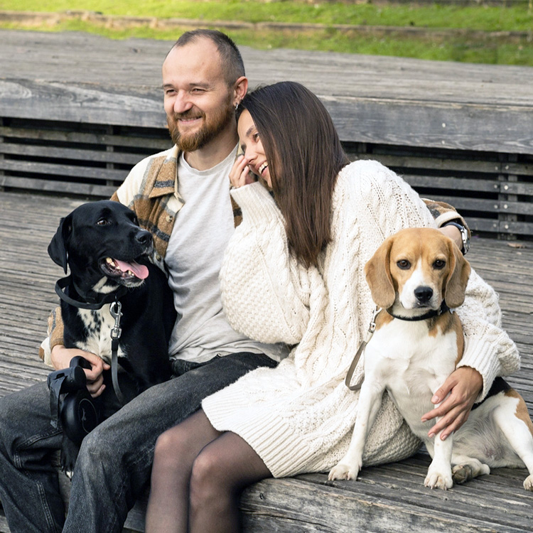 A couple with their dogs outside.