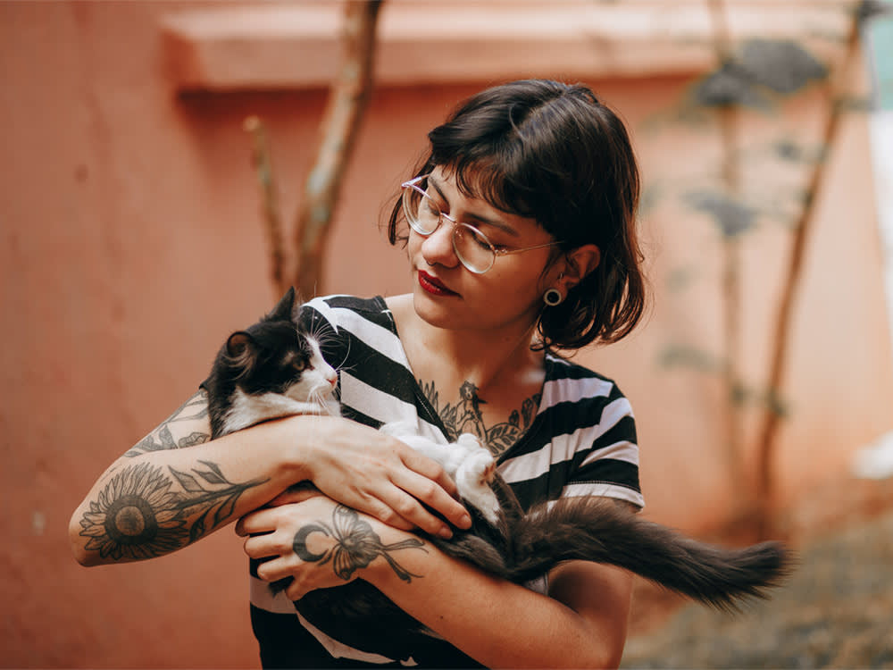 woman holds cat in animal shelter