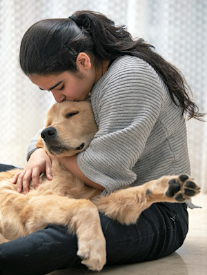 Woman snuggling her Golden Retriever.
