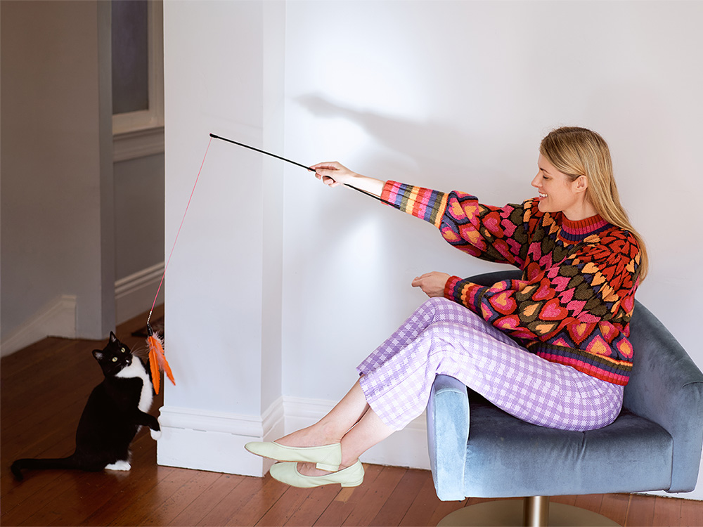 Lisa Buhler playing with her black and white cat