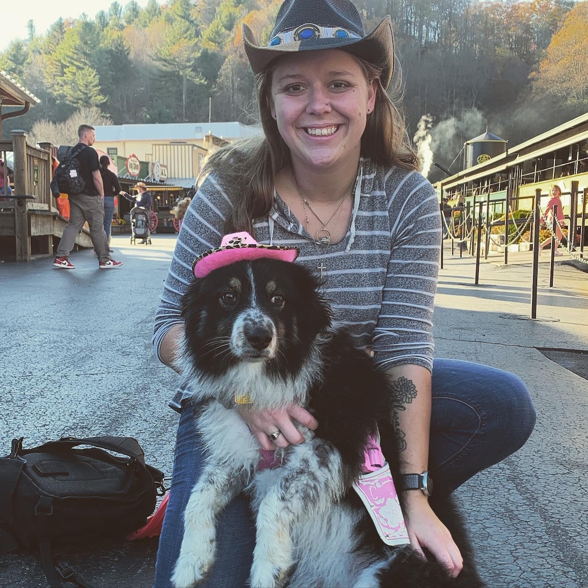 picture of a woman and a sheepdog both wearing cowboy hats in an old west town