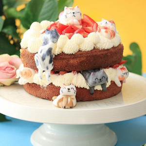 a two-layered cake decorated with icing cats