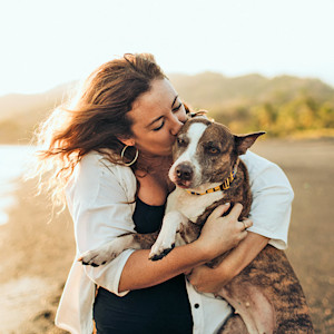 Woman hugging her dog outside.