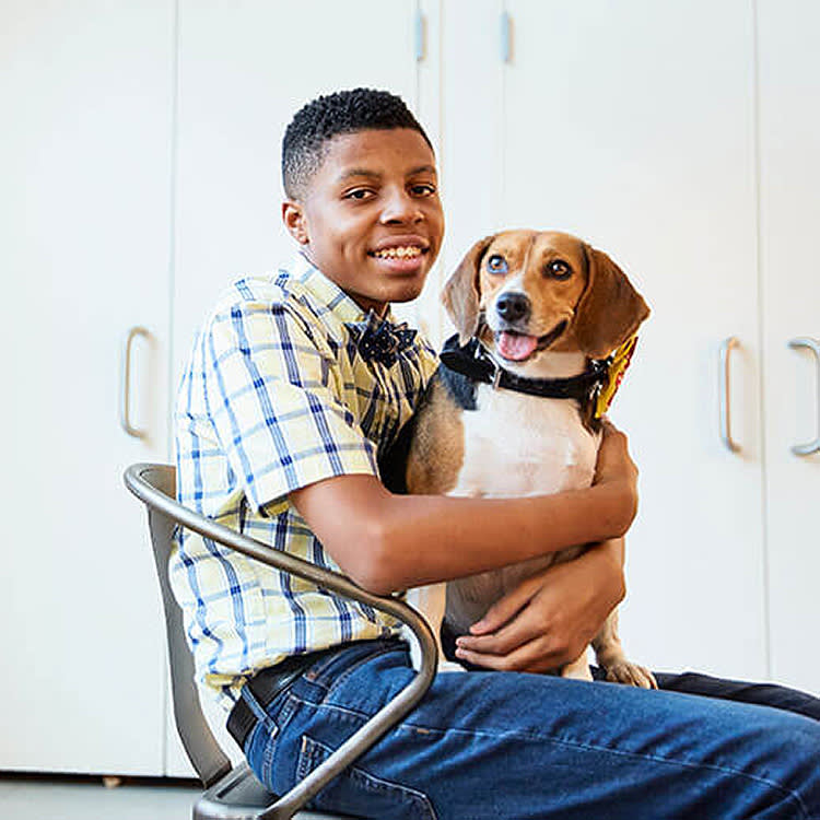 Sir Darius Brown and Beagle dog on his lap.