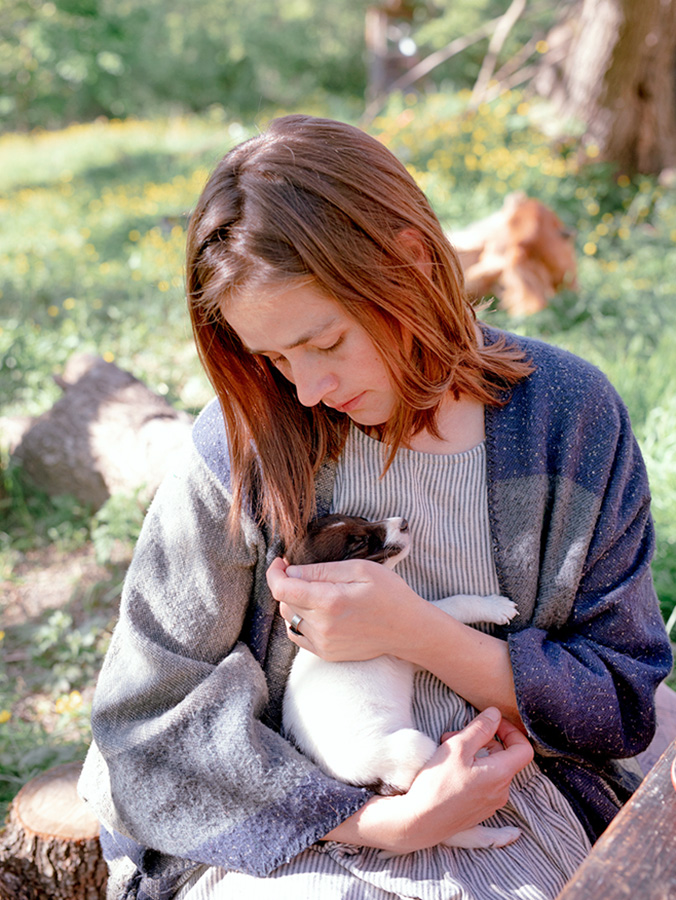 Woman holding her small puppy in her arms.