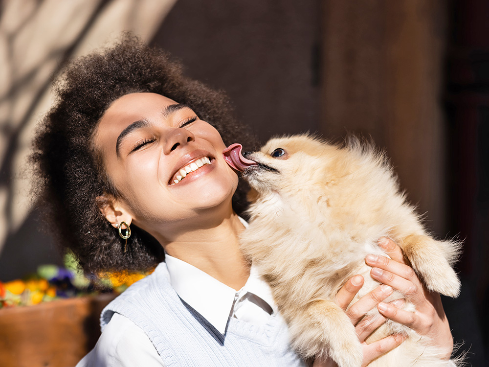 Woman with her Pomeranian dog outside.
