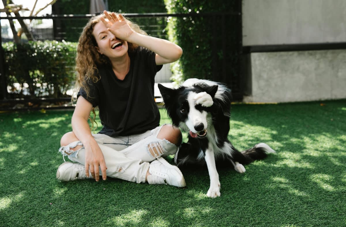 a picture of a woman and a collie dog both covering their left eye and smiling