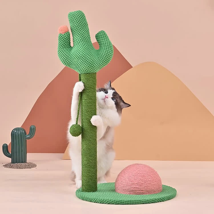 A black and white cat climbing a cactus shaped cat scratching post in front of a warm toned paper background of desert mountains