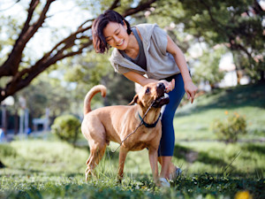Woman playing outside with her dog.