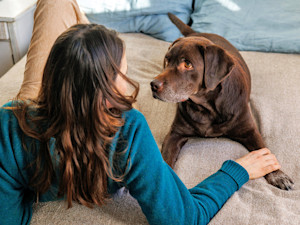 Woman in bed with her dog at home.