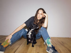 Carly sitting on a floor with her dog 