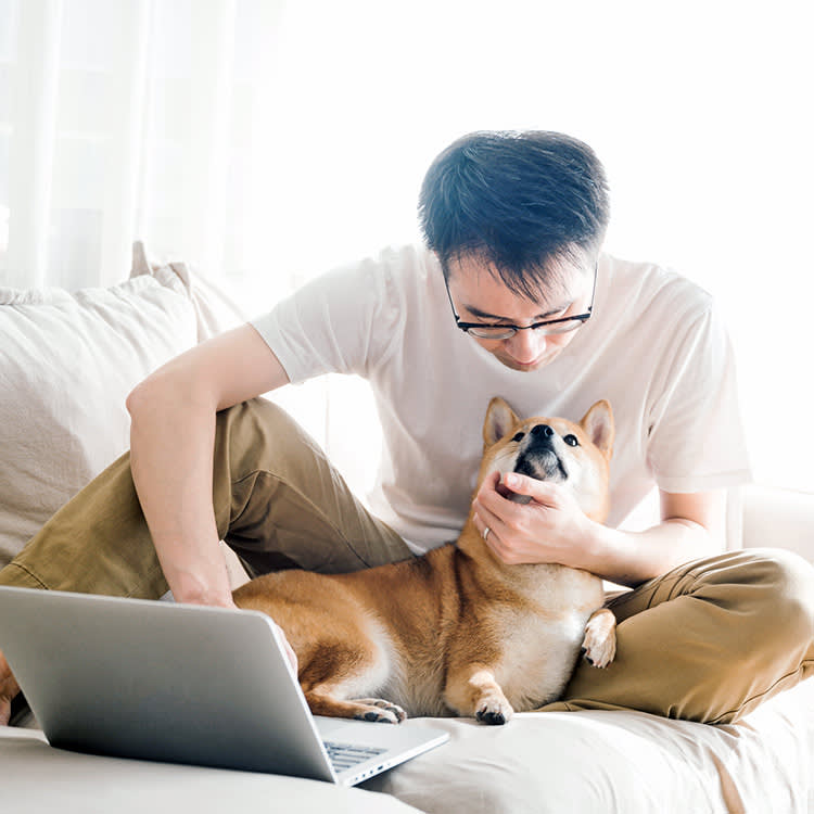 Man looking down at his dog in his lap.