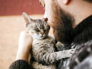 Man holding cat in his arms.