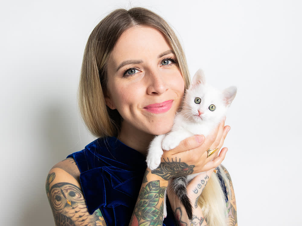 Hannah Shaw holds a white kitten