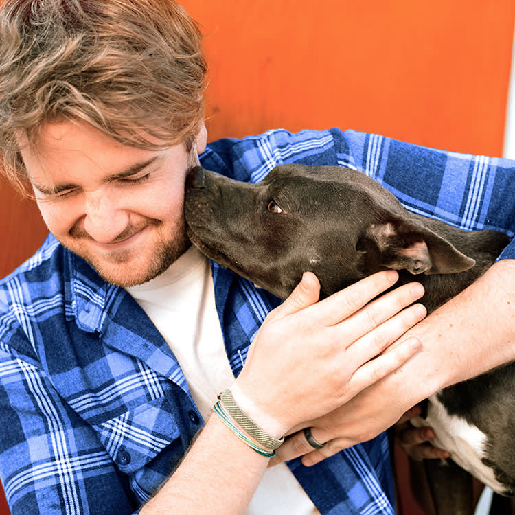 Dog cobbing its male owner outside.