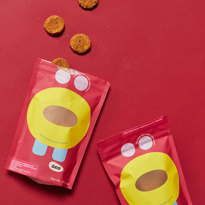 Two bags of Odd Food Dog treats set on a red background