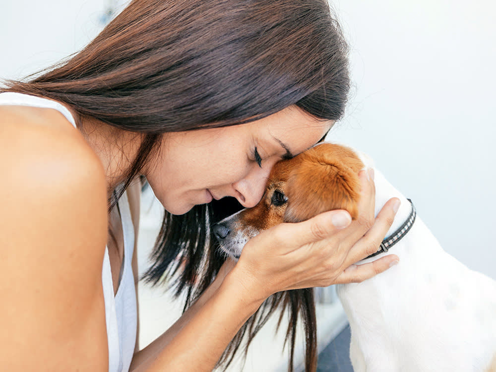 Woman holding her small dog.