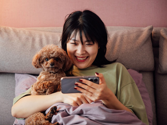 Young woman looking at cellphone with her dog