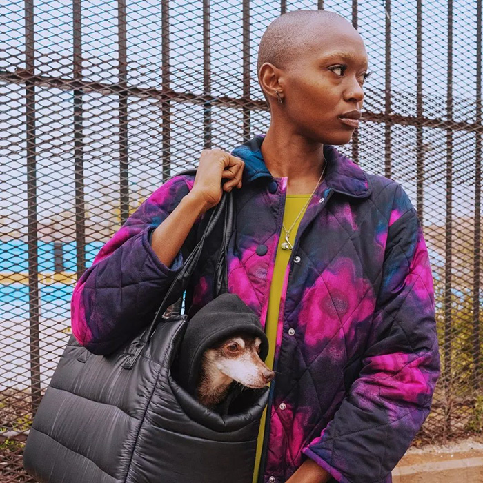 model holding dog in quilted black carry bag 