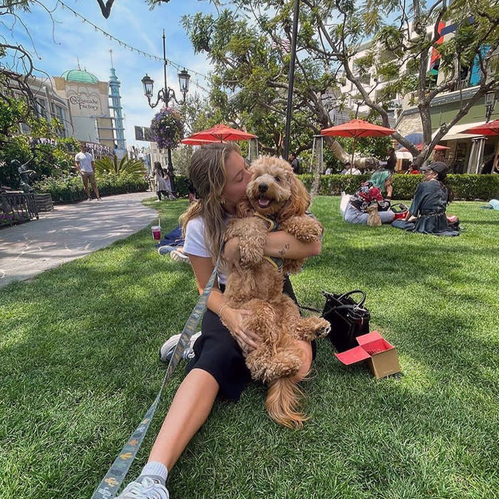 A dog mom cuddles her pup at The Grove