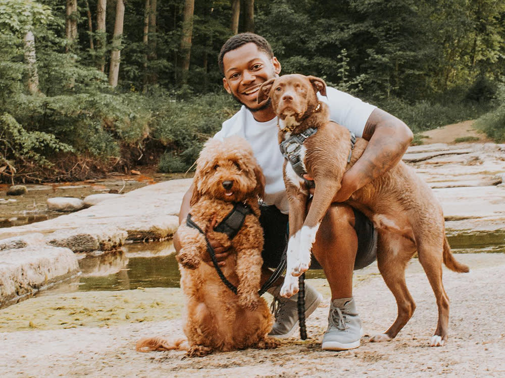 Noah and his two dogs on a nature trail smiling at the camera