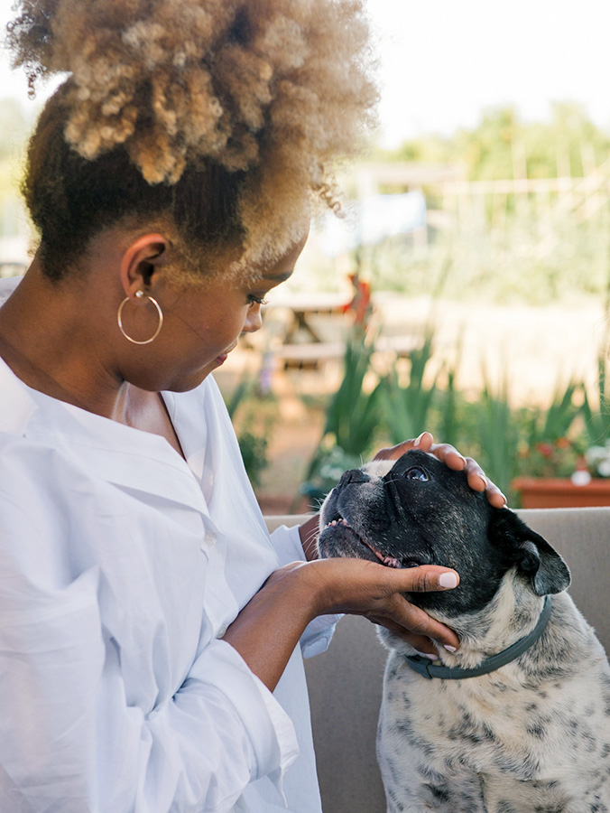 Woman looking into her dog's eyes outside.
