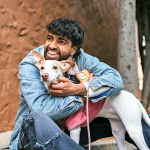 a man poses with a dog