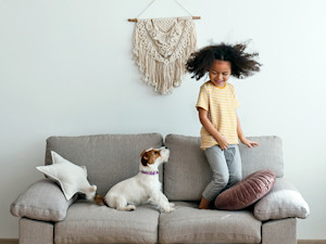 Dog looking uncomfortable around child at home.