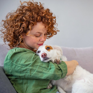 Woman with her dog relaxing in living room.