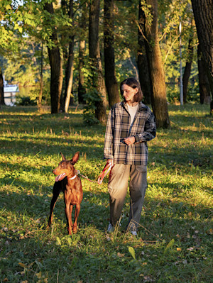 Woman walking her dog in nature.