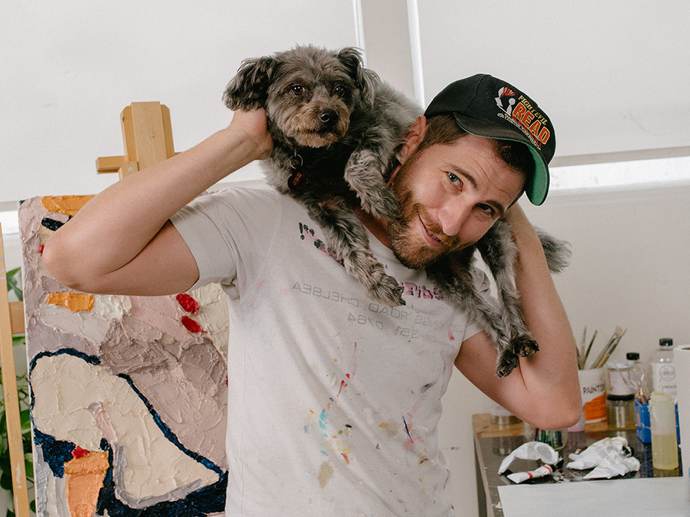 Seth Bogart holds his small brown dog, Stix