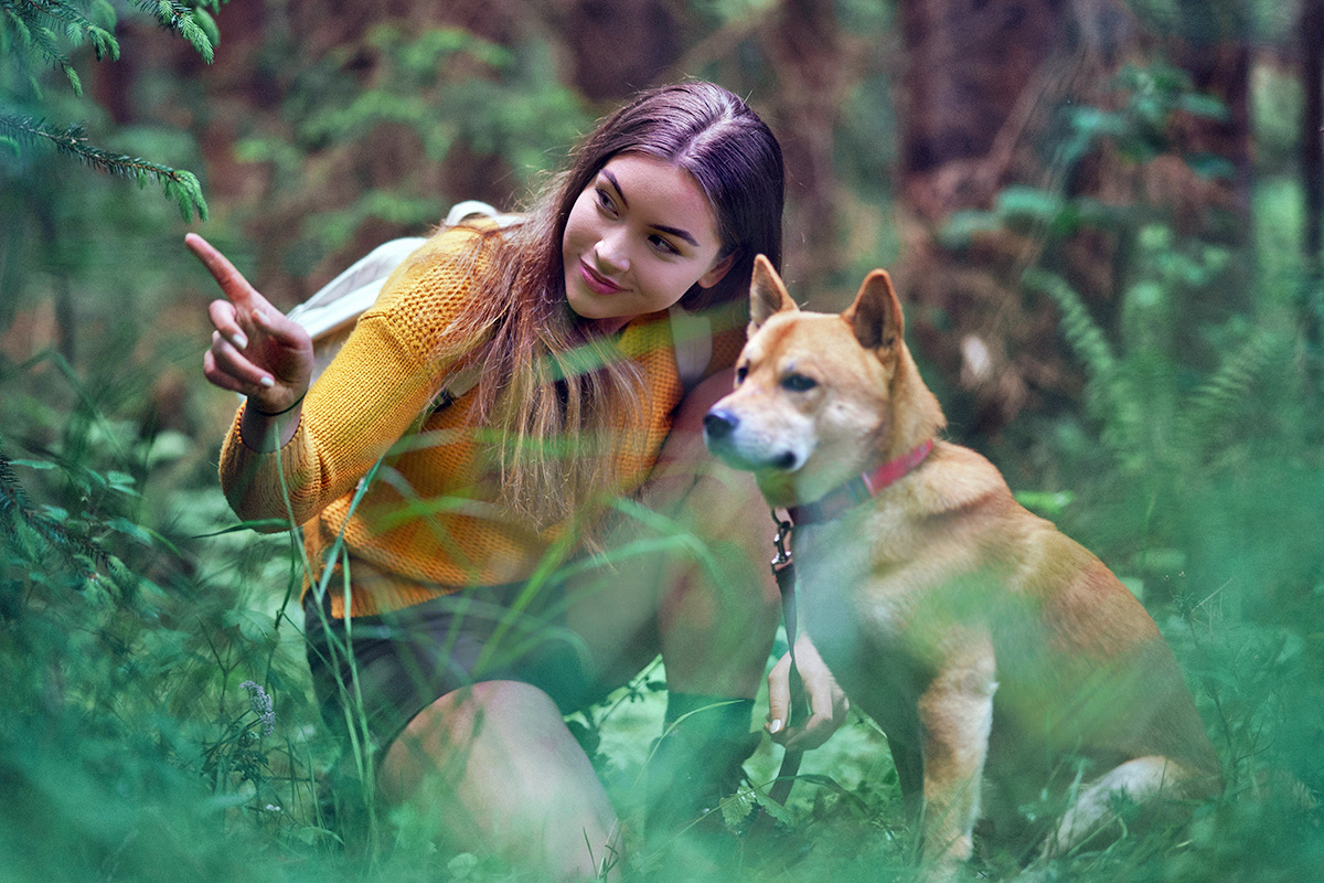 person pointing next to a dog