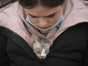 a cat rests in a girl's jacket