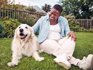 Woman outside her dog in the grass.