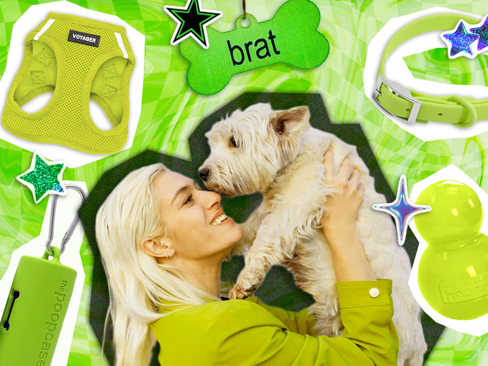 Woman holding her small white dog in the air.