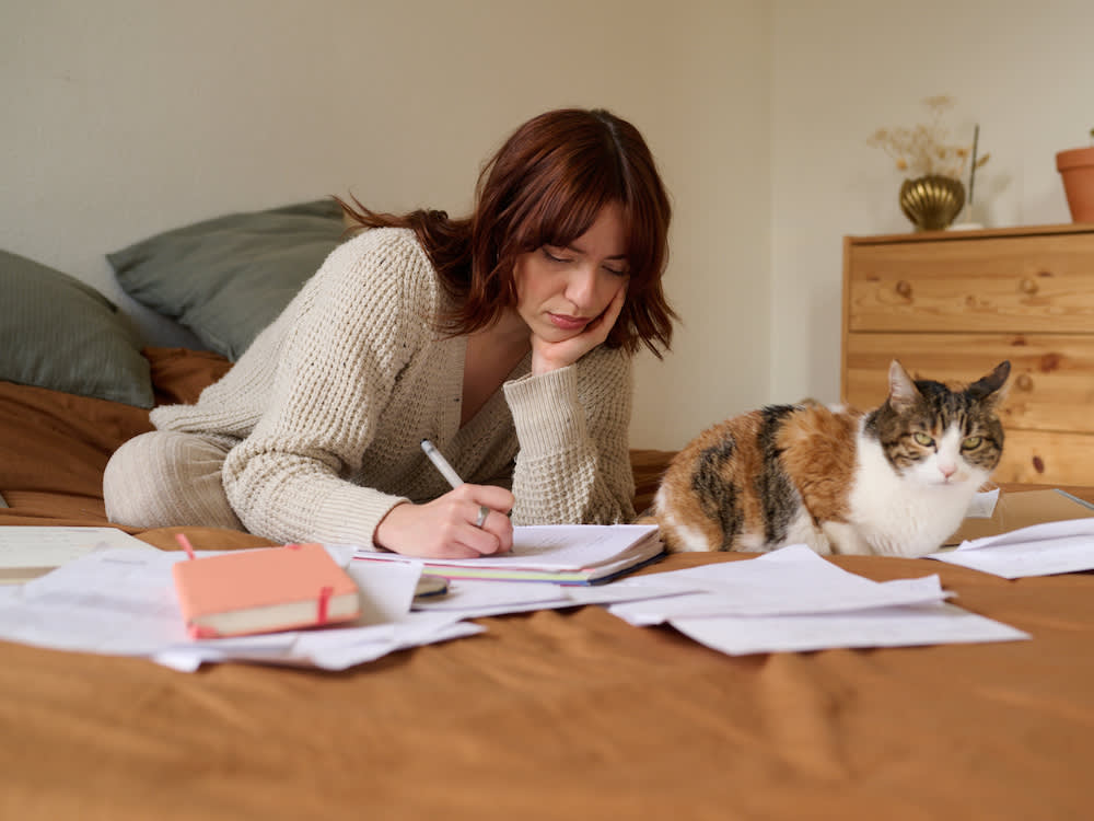 nervous person writing next to a cat