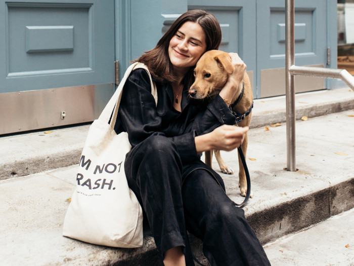 Lauren Singer sitting on street step hugging her tan dog named Rose