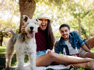 Happy couple outside with their dog.