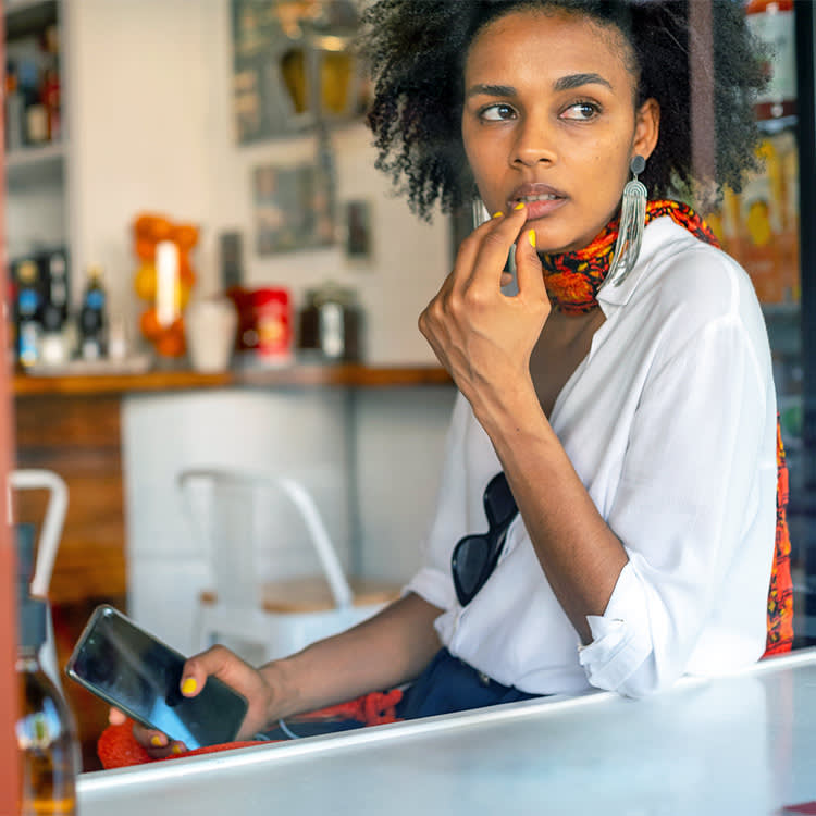 Woman looking worried while gazing out a window.
